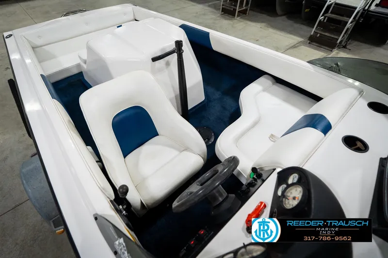 Slide: The Image of 1997 Moomba Boomerang boat interior with white and blue seating, steering wheel, and carpeted floor. - 12