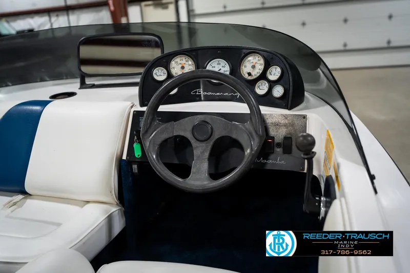 Slide: The Image of 1997 Moomba Boomerang boat interior with open storage compartment and white seating. - 21