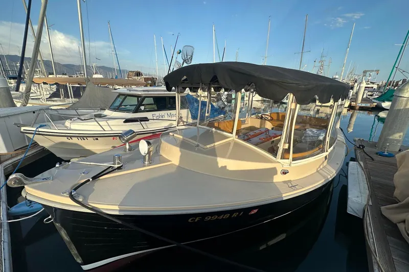 The Image of 2007 Duffy 22 Electric boat docked in a marina, featuring a black canopy. - 0