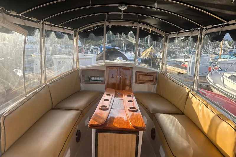 Slide: The Image of Interior of a 2007 Duffy 22 Electric boat with cushioned seating and wooden table. - 12