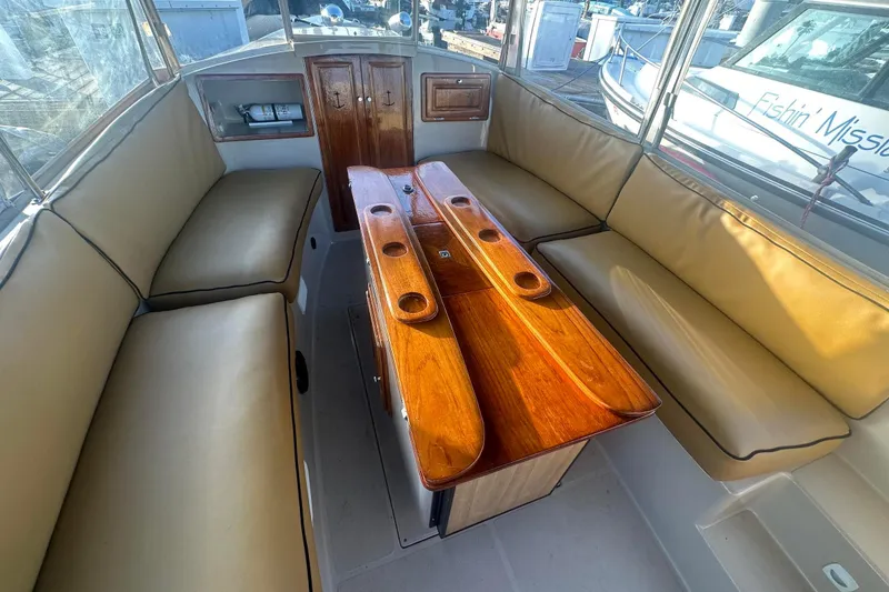 Slide: The Image of Interior of 2007 Duffy 22 Electric boat with beige seating and wooden table. - 14