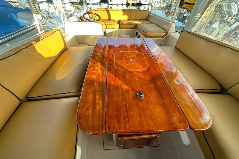 Slide: The Image of Interior of 2007 Duffy 22 Electric boat with wooden table and beige seating. - 15