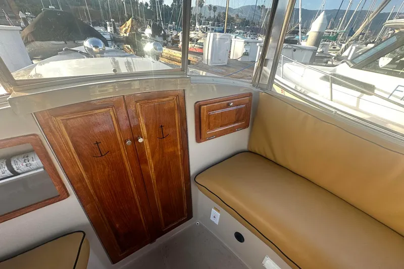 Slide: The Image of Interior of a 2007 Duffy 22 Electric boat with wood cabinets and tan seating. - 17