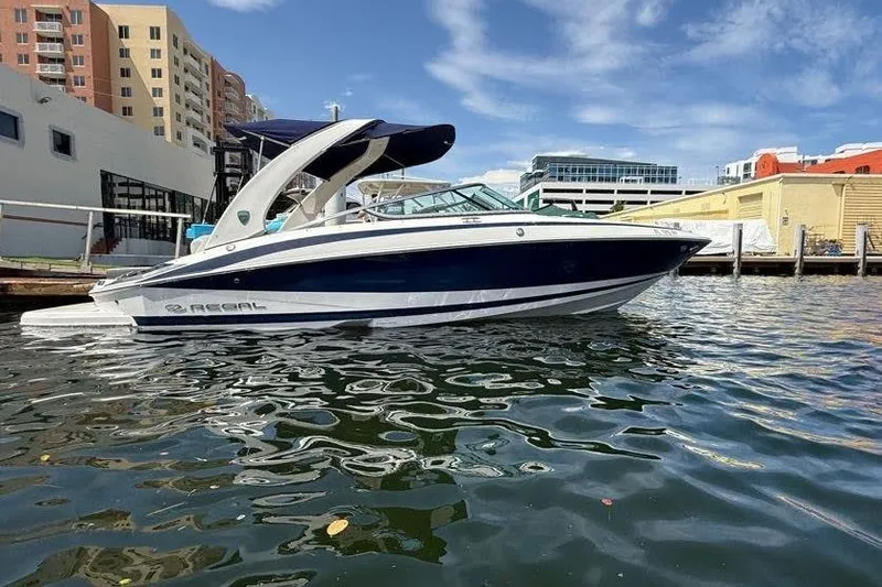The Image of 2014 Regal 2500 Bowrider boat docked in urban marina under blue sky. - 0