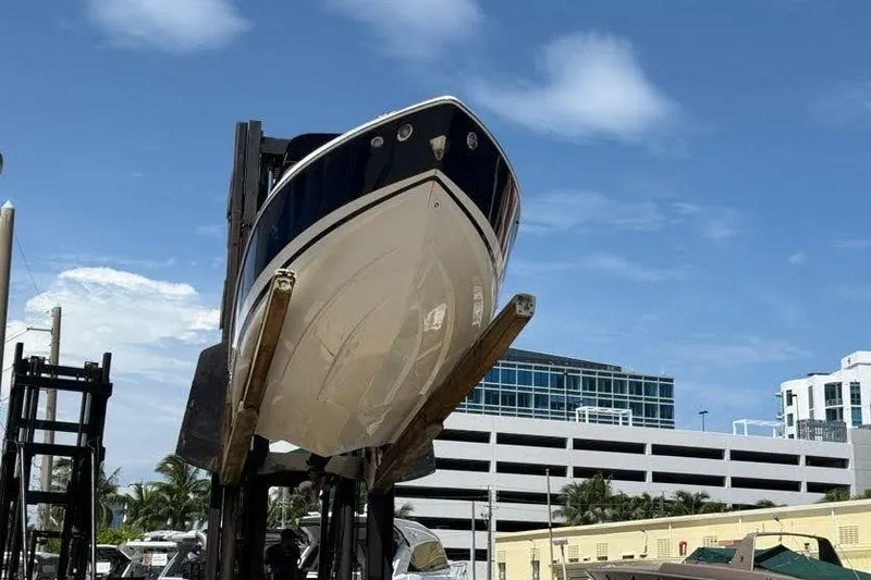 Slide: The Image of 2014 Regal 2500 Bowrider boat lifted on a forklift against a clear blue sky. - 1