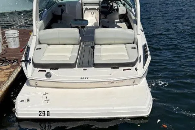 Slide: The Image of 2014 Regal 2500 Bowrider boat docked on water, rear view with seating area. - 9