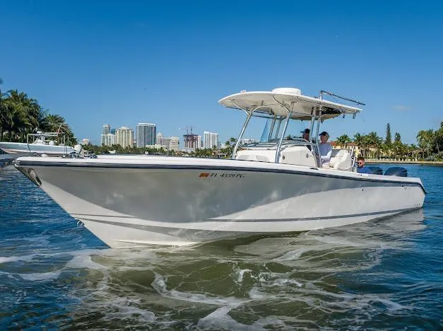 Slide: The Image of 2010 Edgewater 318CC boat cruising on a sunny day near a city skyline. - 11