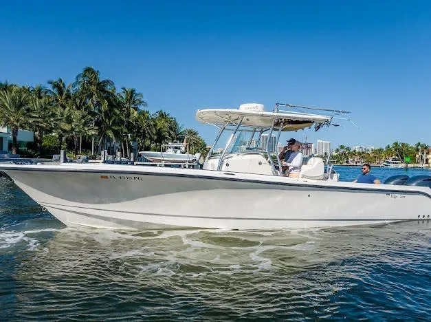 Slide: The Image of 2010 Edgewater 318CC boat cruising on a sunny day near palm trees. - 12