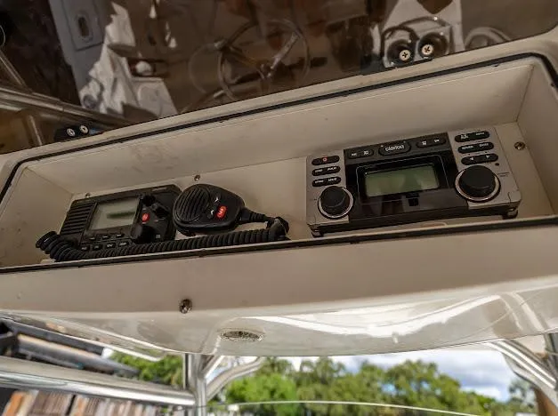 Slide: The Image of Radio equipment on a 2010 Edgewater 318CC boat, featuring communication devices in a storage compartment. - 13