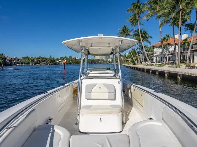 Slide: The Image of Edgewater 318CC 2010 boat cruising on a sunny waterfront with palm trees. - 15