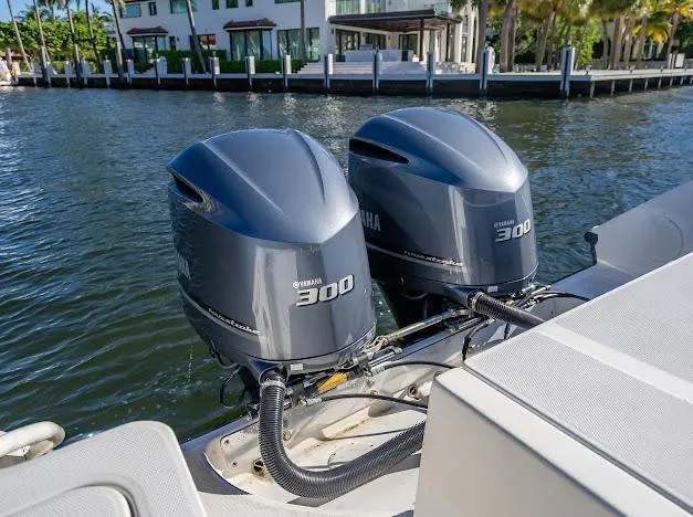 Slide: The Image of Twin Yamaha 300 engines on a 2010 Edgewater 318CC boat, docked by waterfront homes. - 23
