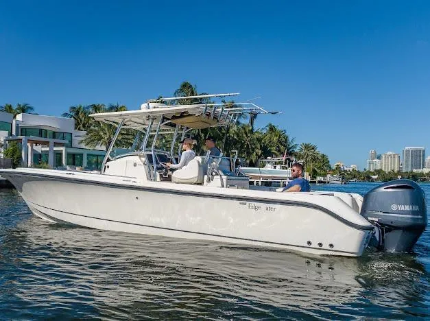 Slide: The Image of 2010 Edgewater 318CC boat cruising on a sunny day with passengers onboard. - 28