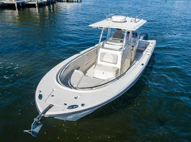 Slide: The Image of 2010 Edgewater 318CC boat on water, featuring sleek design and spacious deck. - 32