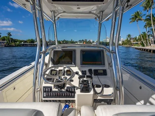 Slide: The Image of Cockpit view of 2010 Edgewater 318CC boat with dual screens and steering wheel on a sunny day. - 34