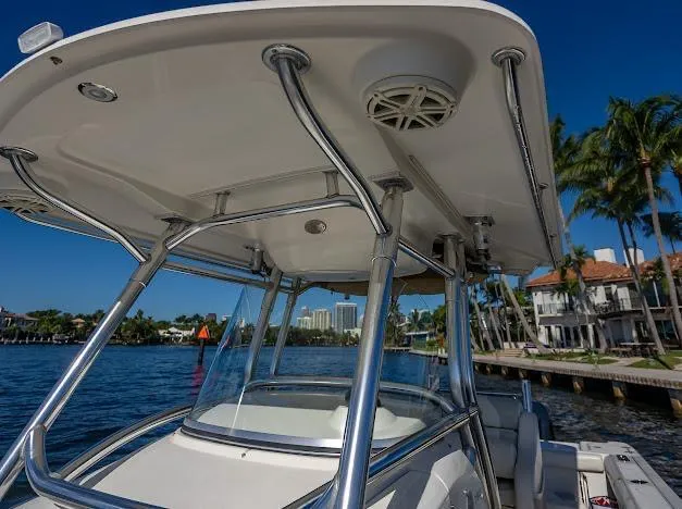 Slide: The Image of 2010 Edgewater 318CC boat with T-top, docked near waterfront homes. - 36