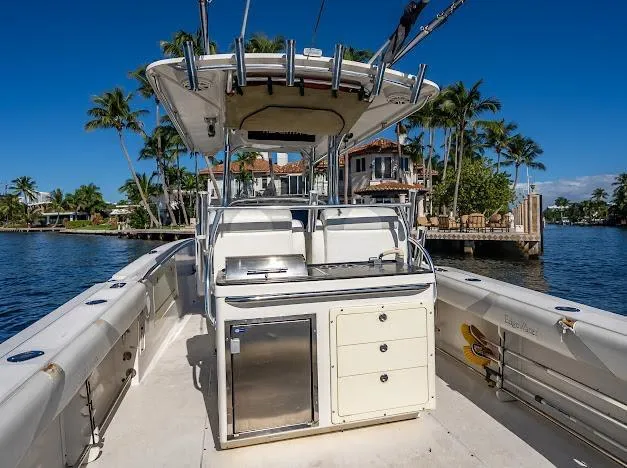 Slide: The Image of Edgewater 318CC 2010 boat with center console, docked near waterfront homes and palm trees. - 37