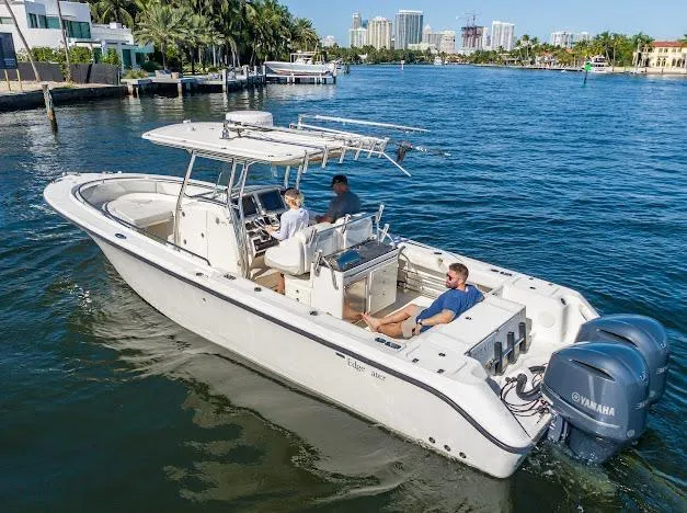 Slide: The Image of 2010 Edgewater 318CC boat cruising on a sunny day with three passengers onboard. - 6