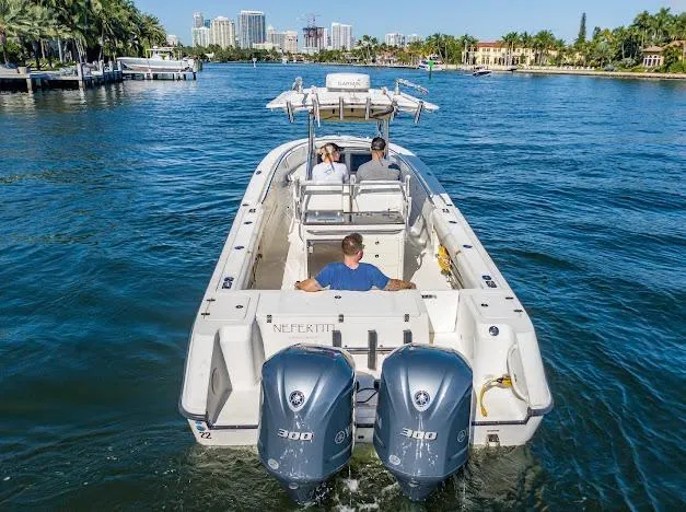 Slide: The Image of 2010 Edgewater 318CC boat cruising on a scenic waterway with three passengers. - 9