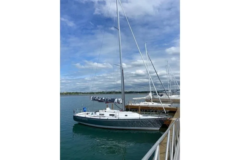The Image of 1990 Tartan Thomas 35 sailboat docked on a calm, sunny day. - 0