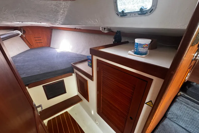 Slide: The Image of Interior of 1990 Tartan Thomas 35 sailboat cabin with wooden finishes and storage. - 22