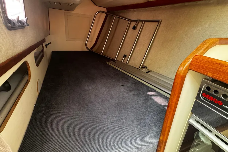 Slide: The Image of Interior cabin of 1990 Tartan Thomas 35 sailboat, featuring carpeted flooring and wooden accents. - 24