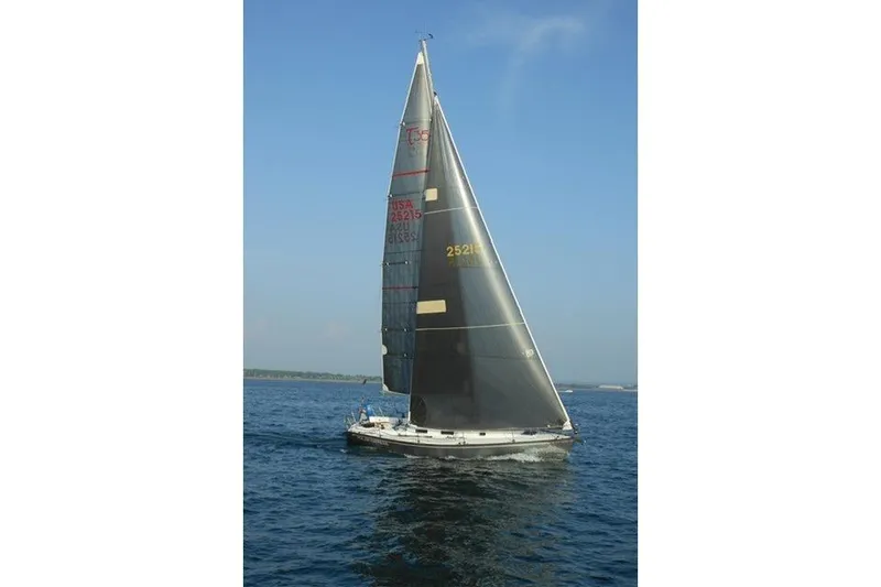 Slide: The Image of Sailboat Tartan Thomas 35, 1990 model, sailing on open water under clear blue sky. - 3
