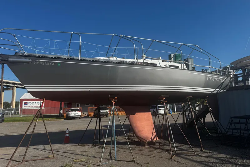 Slide: The Image of 1990 Tartan Thomas 35 sailboat on stands at a marina, clear blue sky background. - 37