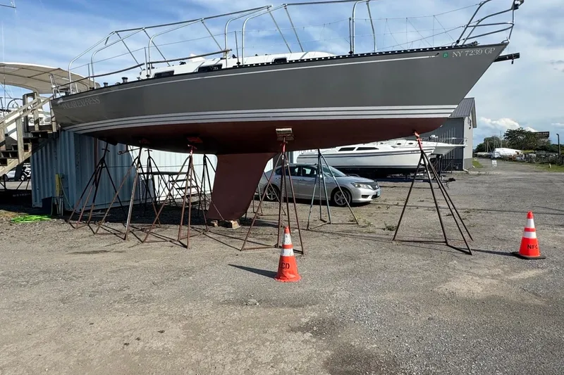 Slide: The Image of 1990 Tartan Thomas 35 sailboat on stands in a boatyard with traffic cones. - 38