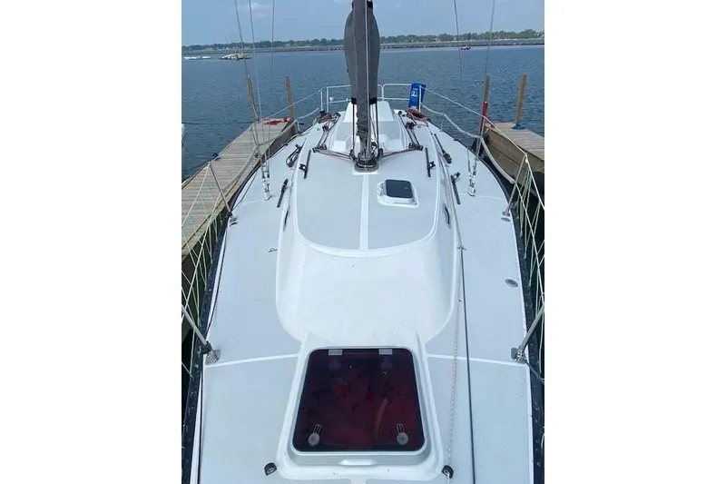 Slide: The Image of 1990 Tartan Thomas 35 sailboat docked, showcasing sleek deck design and rigging. - 5