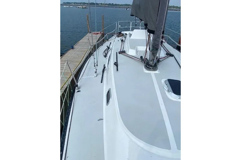 Slide: The Image of 1990 Tartan Thomas 35 sailboat docked, showcasing deck and mast details. - 6