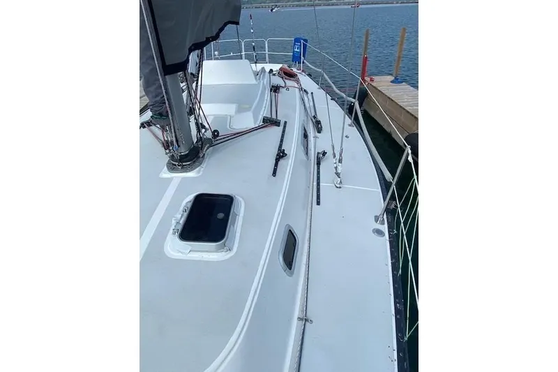Slide: The Image of 1990 Tartan Thomas 35 sailboat deck view at marina, showcasing rigging and hatch. - 7