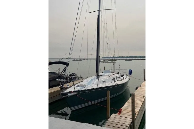 Slide: The Image of 1990 Tartan Thomas 35 sailboat docked at a marina, calm water background. - 9