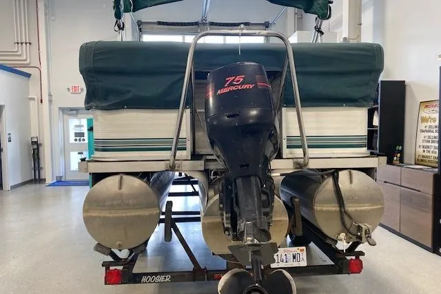 Slide: The Image of 2001 Odyssey Pontoons 1703 Millennium with Mercury 75 engine on trailer indoors. - 3