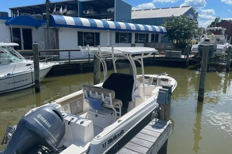 Slide: The Image of 2017 Wellcraft 222 Fisherman boat docked with Yamaha engine, marina background. - 2