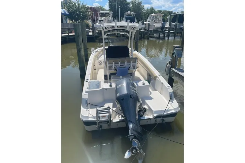 Slide: The Image of 2017 Wellcraft 222 Fisherman boat docked, featuring an outboard motor and spacious deck. - 5