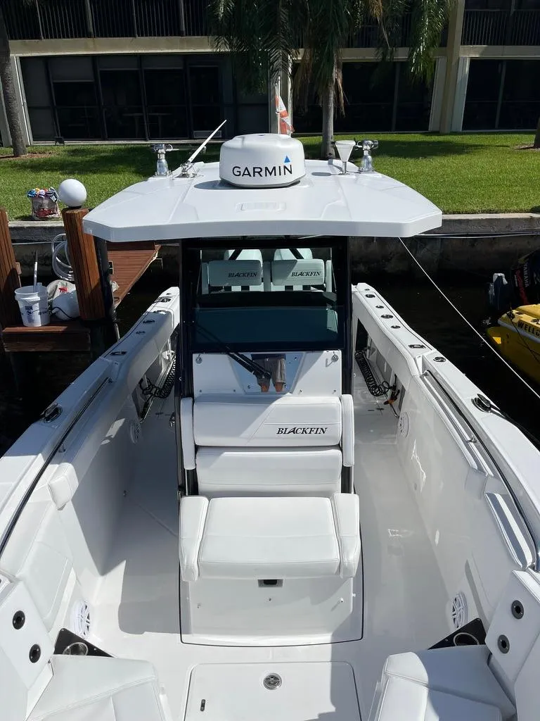Slide: The Image of 2019 Blackfin 272 CC boat with Garmin equipment, docked near a grassy area. - 36