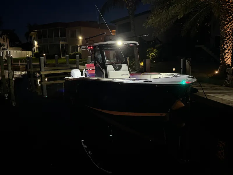 Slide: The Image of 2019 Blackfin 272 CC boat docked at night, illuminated by lights. - 4