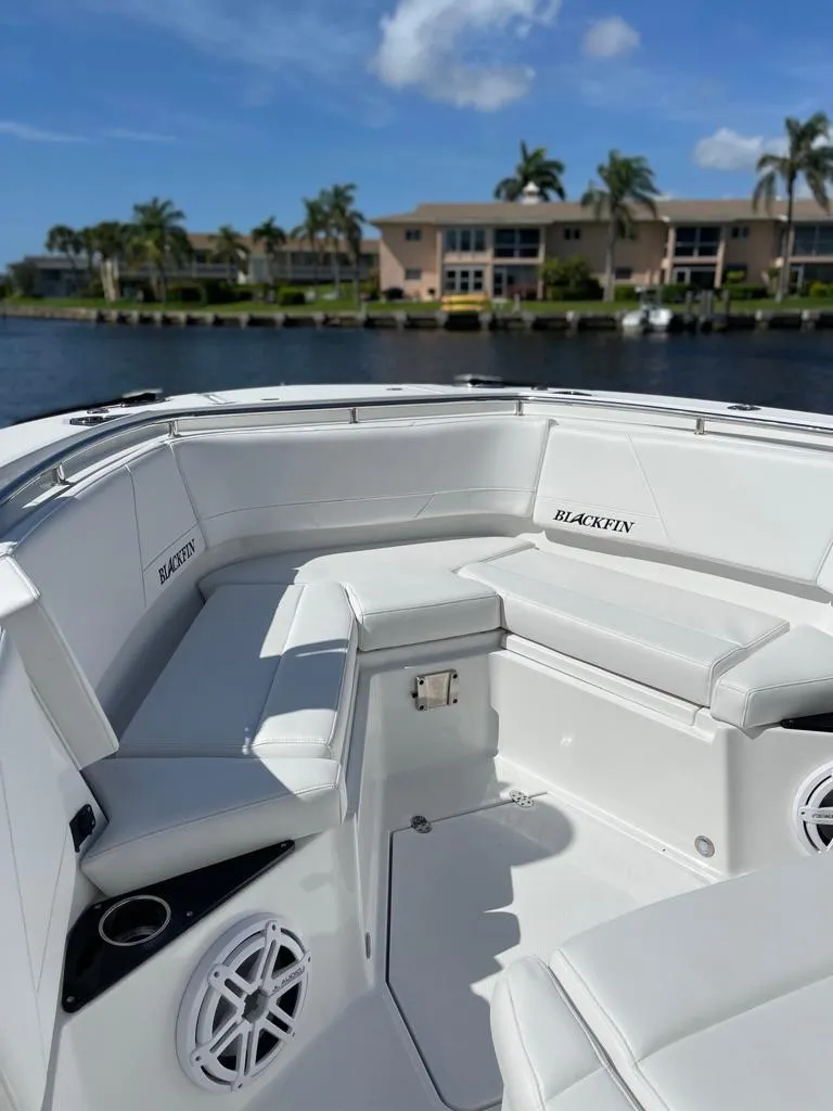 Slide: The Image of 2019 Blackfin 272 CC boat with white seating, docked near waterfront homes. - 41