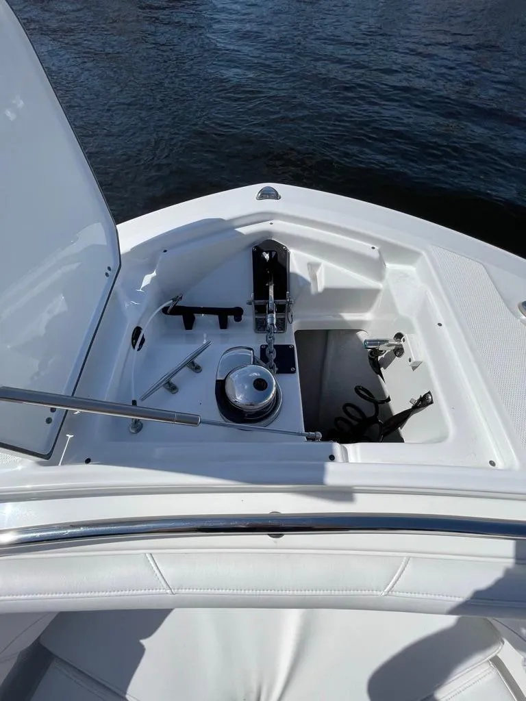 Slide: The Image of 2019 Blackfin 272 CC boat anchor compartment with open hatch, docked on water. - 42