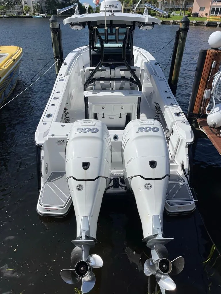 Slide: The Image of 2019 Blackfin 272 CC boat with twin 300 horsepower engines docked by the water. - 6