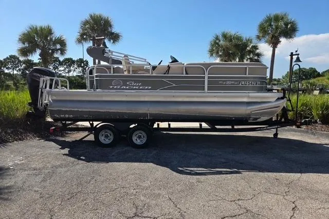 The Image of 2017 Sun Tracker Party Barge 20 DLX pontoon boat on trailer, parked outdoors. - 0