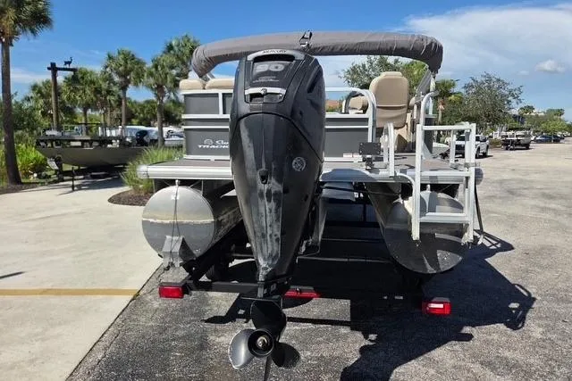Slide: The Image of 2017 Sun Tracker Party Barge 20 DLX pontoon boat with outboard motor, parked outdoors. - 3