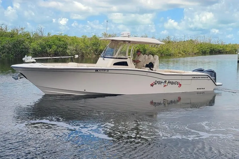 Slide: The Image of 2020 Grady-White Canyon 326 boat cruising on calm water with scenic background. - 10