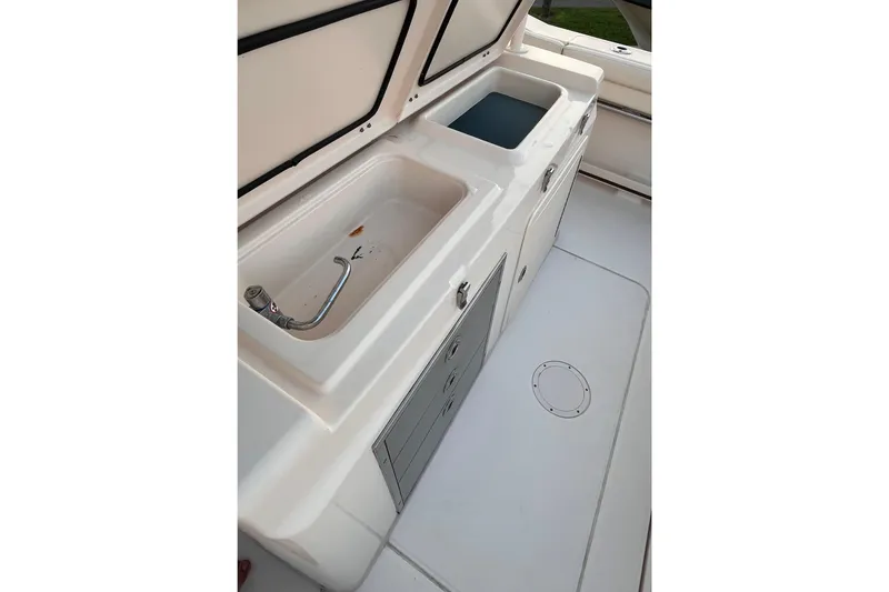 Slide: The Image of 2020 Grady-White Canyon 326 boat sink and storage area, featuring dual compartments. - 18