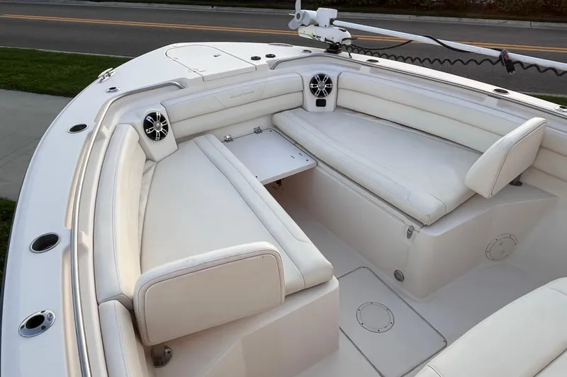 Slide: The Image of 2020 Grady-White Canyon 326 boat interior with white cushioned seating and speakers. - 28