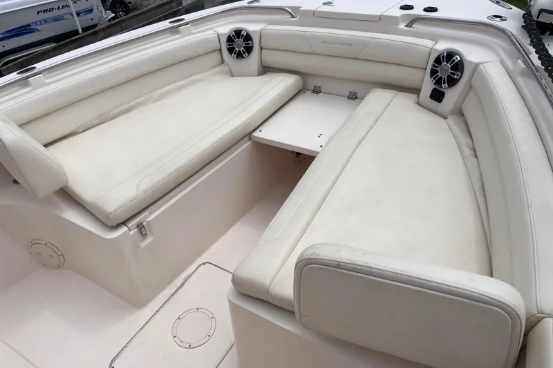 Slide: The Image of 2020 Grady-White Canyon 326 boat interior with white cushioned seating and speakers. - 30