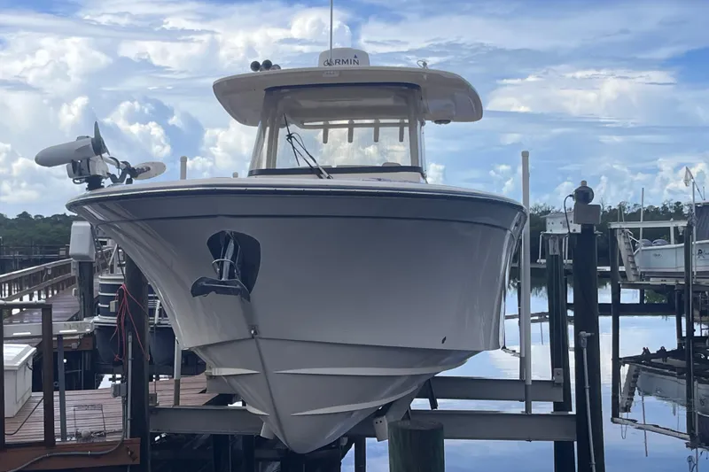 Slide: The Image of 2020 Grady-White Canyon 326 boat docked at marina under cloudy sky. - 36