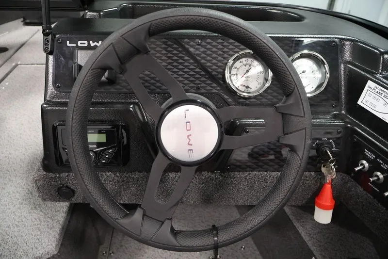 Slide: The Image of 2026 Lowe Fishing Machine 1875 dashboard with steering wheel and gauges. - 15