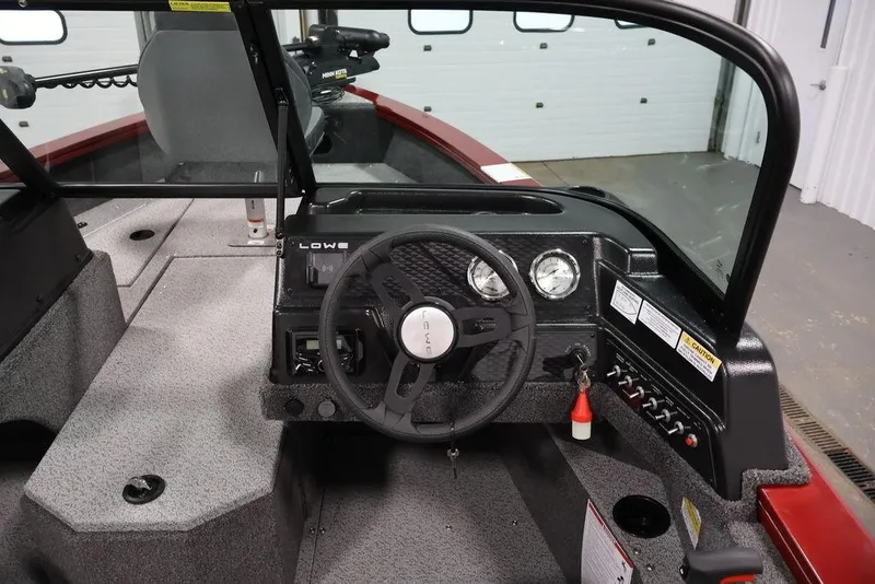 Slide: The Image of 2026 Lowe Fishing Machine 1875 boat interior with steering wheel and dashboard controls. - 16