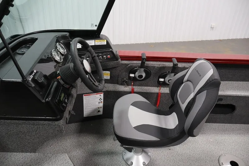 Slide: The Image of 2026 Lowe Fishing Machine 1875 interior with steering wheel and comfortable seating. - 17